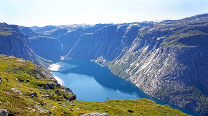 Fototapeta na wymiar Top view of lake between mountains, picturesque landscape, beauty in nature, sunny day, hiking way to Trolltunga cliff (The Troll's tongue), Odda, Norway