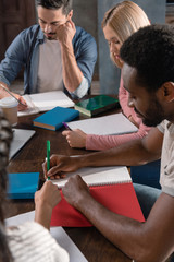 multiethnic students writing in copybooks