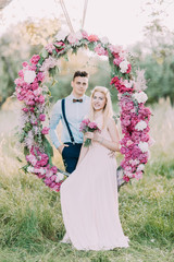 The vertical photo of the bridesmaid with the bouquet of pink flowers sitting on the wedding...