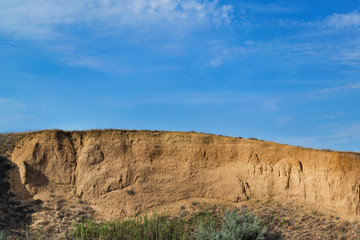 Epic view of the steep rock and the bright sky with clouds