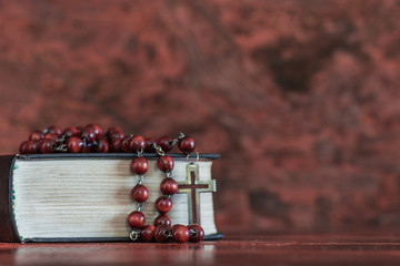 Bible and a crucifix on an old table. Beautiful background.Religion concept.