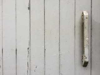 Renovierungsbedürftige Holzlatten einer Tür mit alter grauer Farbe