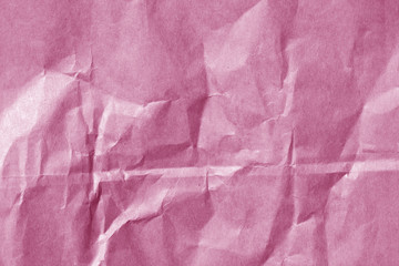 Pink color paper sheet surface with wrinckles.