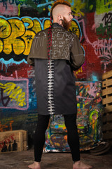 A creative, unusual red-haired man in designer clothes and tunnels in his ears, posing in the...