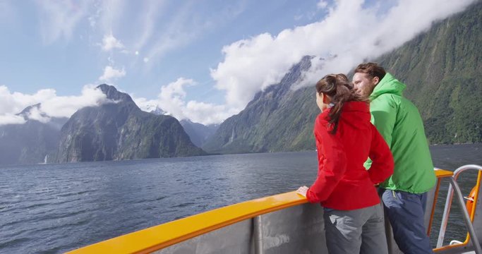 Cruise ship tourists on boat tour in Milford Sound, Fiordland National Park, New Zealand. Happy couple on sightseeing travel on New Zealand South Island. RED EPIC SLOW MOTION.