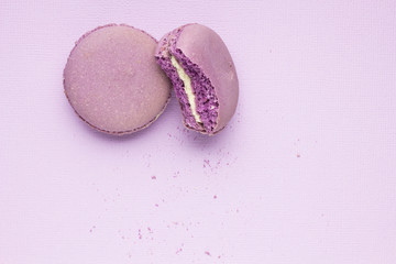 Obraz na płótnie Canvas Have a bite / Creative photo of macaroons on purple background.