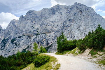 Old gravel road over Vrsic pass to Soca valley. Prisank - prisojnik, mountain with Pagan girl face in the background.
