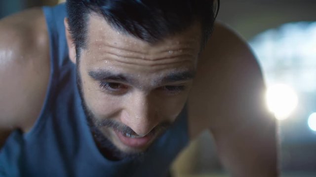 Exhausted Muscular Man Raises His Head and Looks into Camera. He's Covered in Sweat and Tries to Catch a Breath. Shot on RED EPIC-W 8K Helium Cinema Camera.