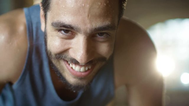 Exhausted Bend Muscular Man Looks into Camera and  Rests After Intensive Workout. He's In a Gym and Covered in Sweat. He Tries to Catch a Breath. Shot on RED EPIC-W 8K Helium Cinema Camera.