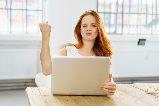 frau am laptop ballt zufrieden die faust