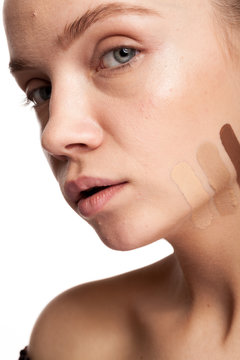 Woman with stripes of different type of cream on face. Studio photo. Beauty and skin care