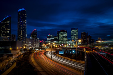 Naklejka na ściany i meble Cityscape of London at night in Canary Wharf, The city’s second largest financial center, with light trails on the freeway leading to the modern skyscrapers of this district, a landmark of England, UK
