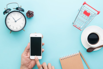 Creative flat lay of woman hands using smartphone, Online shopping concept on blue color background