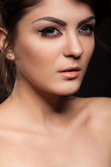 Beautiful gorgeous brunette model in studio photo on black background. Perfect make up and hairstyle