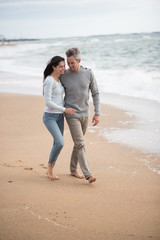  middle-aged couple walking on the beach