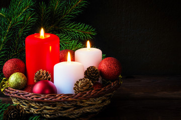 Christmas candles, Christmas decorations balls and chics in a basket on a dark background with copy space