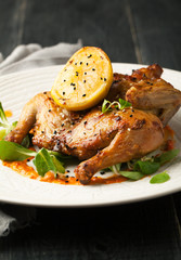 Fried quail with sauce and spices on a white plate