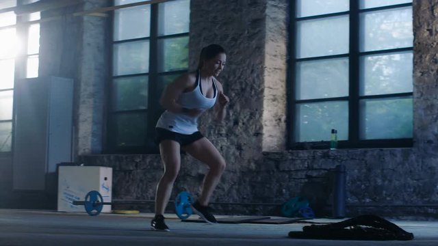 Fit Athletic Woman Does Footwork Running Drill in a Deserted Factory Remodeled into Gym. Cross Fitness Exercise/ Workout Aimed at Strengthening Legs, Enhancing Her Agility and Speed. 