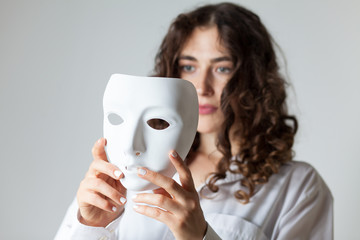 young woman holding a white mask 