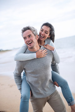 A beautiful couple in their thirties walks on the beach