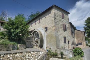 Fototapeta na wymiar Country house with watermill near Castell'Arquato