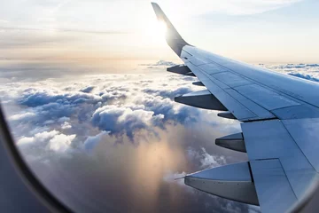 Rolgordijnen uitzicht op het wolkenlandschap vanuit het vliegtuigraam © babaroga