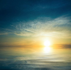 Plakaty  Zachód słońca na bezwietrznym, spokojnym morzu.