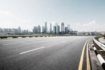 Obraz premium empty road with cityscape of modern city in blue sky