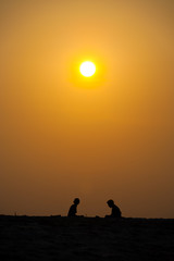 Fototapeta na wymiar Two People Silhouette Beach Orange Sunset Sun Sky