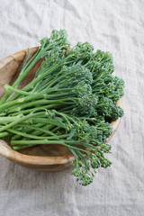 Raw wild broccoli Cime di Rapa in bowl made of olive wood