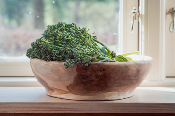 Raw wild broccoli Cime di Rapa in bowl made of olive wood