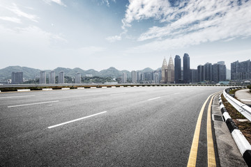 empty road with cityscape of modern city in blue sky