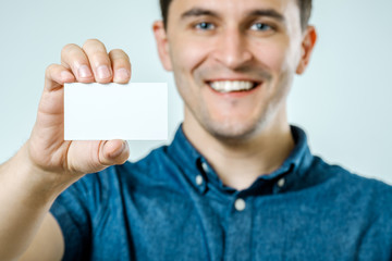 Young man showing blank business card or sign