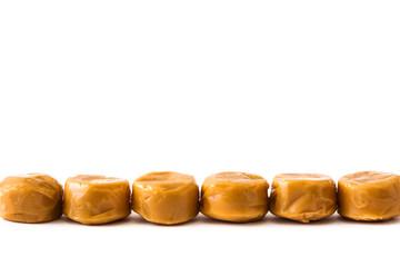Toffee caramel candies isolated on white background. Copyspace.
