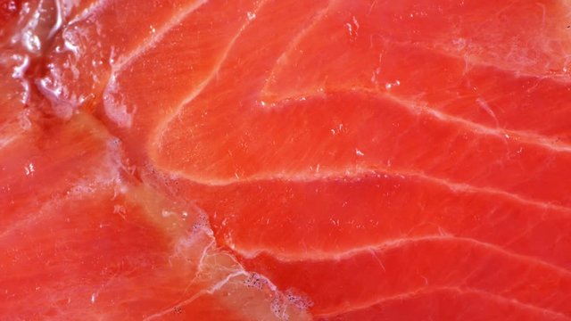 Cutting salted smoked red fish close-up with the effect of scaling