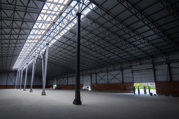 A huge metal construction warehouse. Grain dryer and threshing floor. Blurred-unrecognizable faces of people. Concept theme is the production of food and agricultural production.