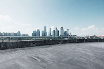 empty concrete road with cityscape of modern city in blue sky