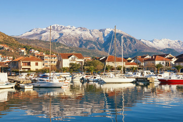 Fishing boats in harbor.  Marina Kalimanj  in Tivat town on a sunny winter day with Lovcen mountain in the background, Montenegro