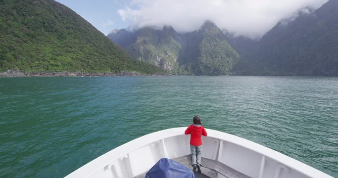 Cruise ship in New Zealand Milford Sound Fiordland National Park. Tourist enjoying boat tour travel and amazing view of fjord in most famous travel destination in New Zealand.