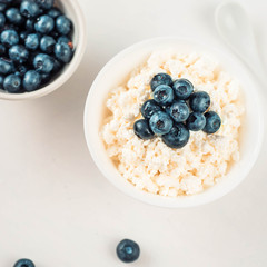 cottage cheese and blueberry in a bowl on a table, top view, copy spase