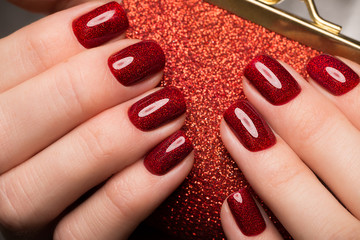 Bright festive red manicure on female hands. Nails design.