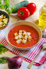 Tomato soup gazpacho with crackers, ingredients and herbs