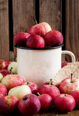 Cup with small red apples Autumn harvest background Beautiful ripe apples Vertical