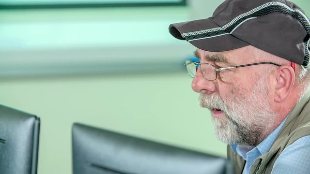 Grandpa is trying to learn together with hsi grandson. They are learning basic computer skills.