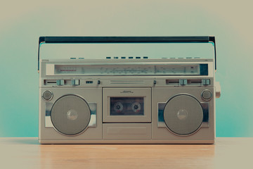 Old retro blaster cassette tape recorder on table in front background