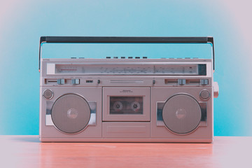 Old retro blaster cassette tape recorder on table in front background