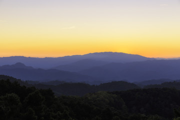 The mountains of layer in the sunset and mist in golden hour sky