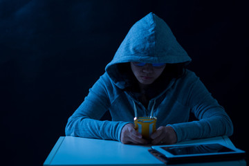 hacker in front computer with laptop / stealing information /Hacking the Internet/Dark face