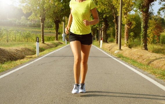 Fitness woman running on asphalt road