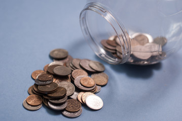 Glass jar with money, coins spilled from a piggy Bank,